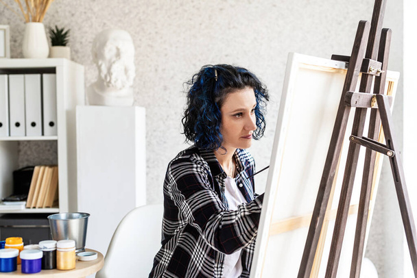 Donna artista creativa che dipinge un quadro lavorando nel suo studio - Foto, immagini