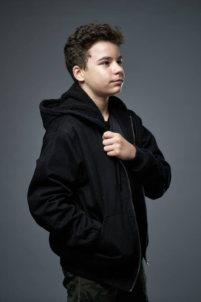 Closeup portrait of a trendy teenage boy over gray background - Photo, image