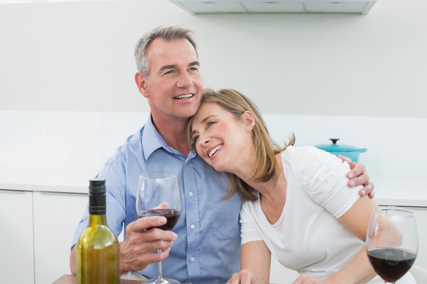 Loving couple with wine glasses in kitchen - Zdjęcie, obraz