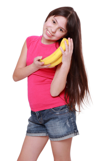 Smiley cheerful little girl holding yellow bananas - Foto, Imagem