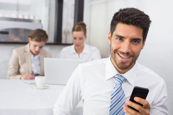 Businessman text messaging with colleagues at office desk - Foto, immagini