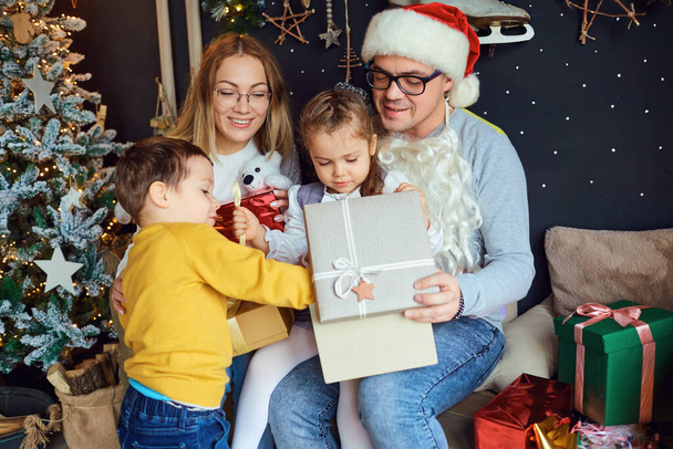 Happy family opening Christmas gifts - Photo, Image