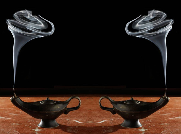 Fotografía de humo blanco procedente de dos lámparas simétricas de Aladdin sobre fondo negro, Foto con espacio para publicidad, espacio en blanco para su texto promocional o contenido publicitario, horizontal  - Foto, Imagen