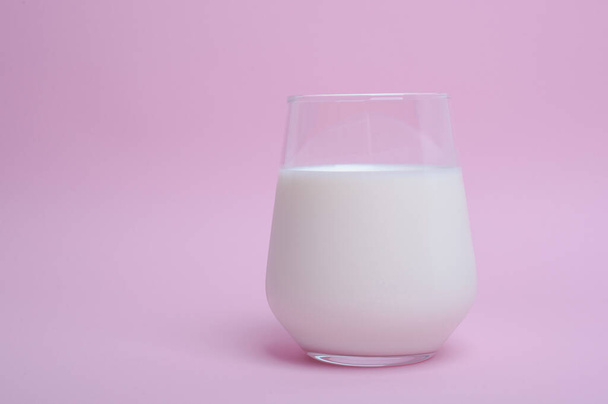  vaso con leche sobre fondo rosa - Foto, Imagen