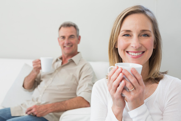 Relaxed couple with coffee cups in living room - Foto, immagini