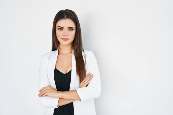 Smiling trendy businesswoman with crossed arms posing on white with copy space - Foto, Imagem