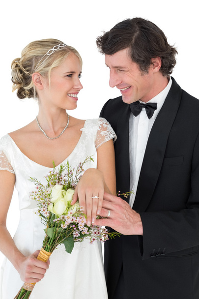 Bride and groom wearing wedding rings over white background - Fotoğraf, Görsel