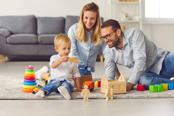 Happy young parents and their child enjoying weekend at home and playing together - Fotoğraf, Görsel