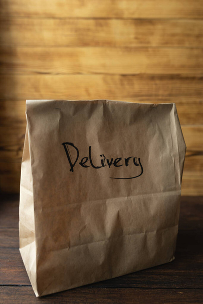 Craft package with food delivery on dark wooden background - Foto, Bild