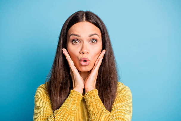 Photo portrait of shocked woman with two hands touching face cheeks isolated on pastel blue colored background - 写真・画像