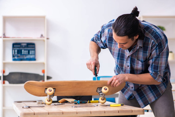 Молодий чоловік ремонтує скейтборд на майстерні
 - Фото, зображення