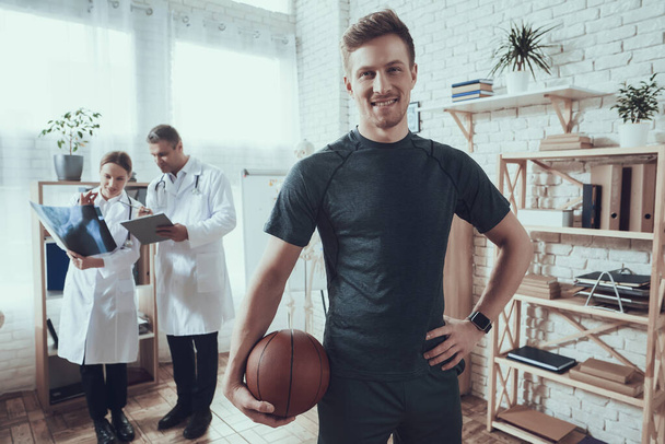 Man basketball player stands in the office. - Zdjęcie, obraz