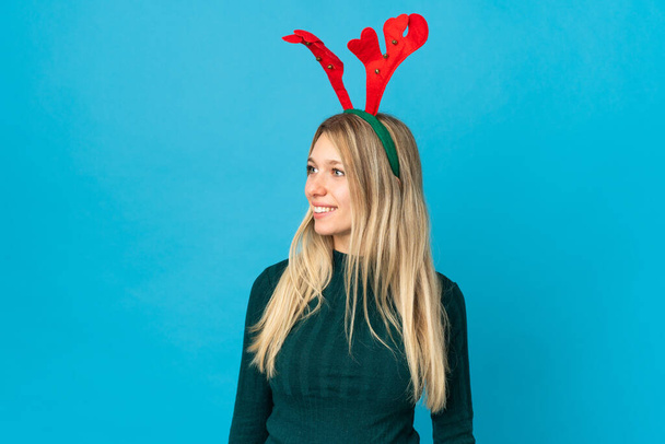 Nő karácsonyi kalap elszigetelt kék háttér látszó oldalán - Fotó, kép