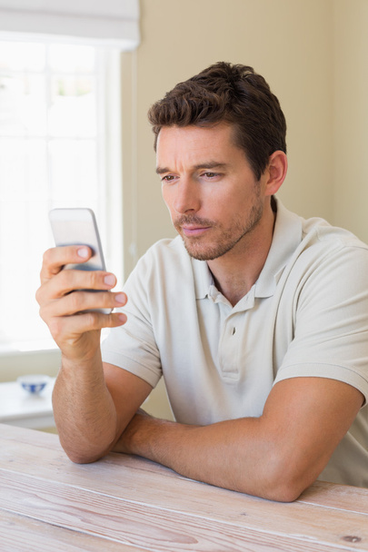 Concentrated man text messaging in home - Foto, Imagem