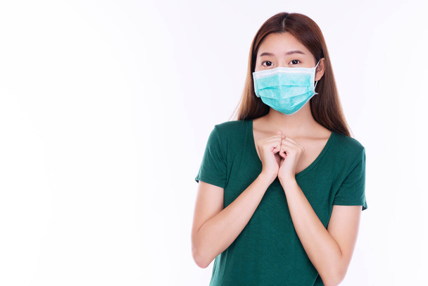 Концепция здравоохранения. Молодая студентка носит медицинскую маску безопасности защиты от вдыхания воздушно-капельных бактерий или вирусных заболеваний и загрязнения воздуха на носу на изолированном белом фоне.  - Фото, изображение