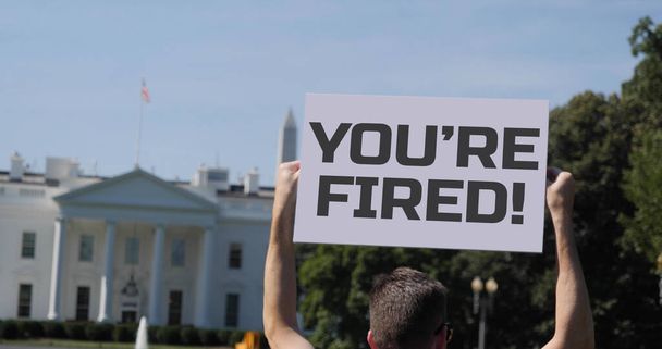 男はあなたが解雇された保持しています！ホワイトハウスの外で抗議サインだ。2020年大統領選挙でジョー・バイデンがドナルド・トランプを破った後、ホワイトハウスの外に集まった人々.   - 写真・画像