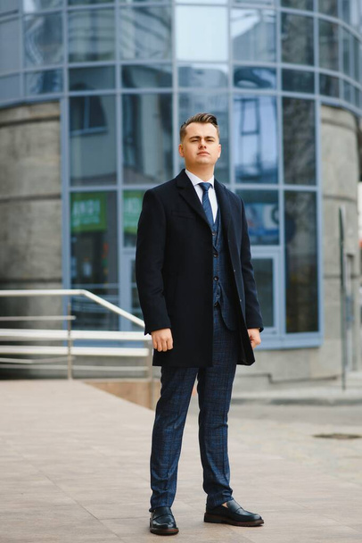High fashion look.Young stylish confident handsome businessman model in suit clothes walking in the street. - Zdjęcie, obraz