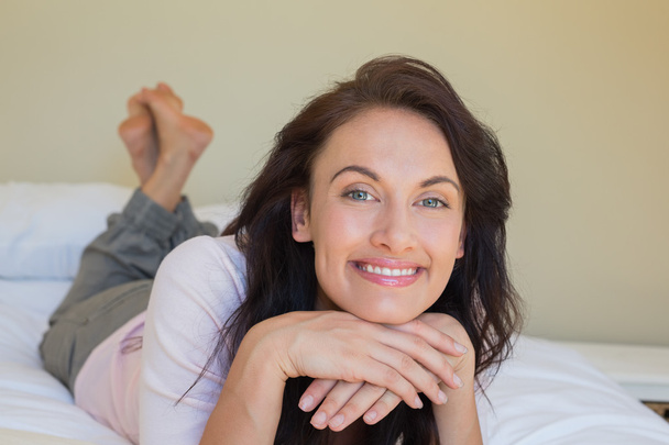 Portrait of confident woman smiling in bed - Foto, imagen