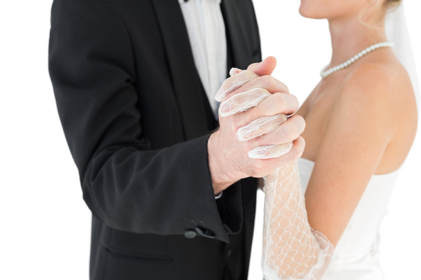 Mid section of bride and groom holding hands - Фото, изображение