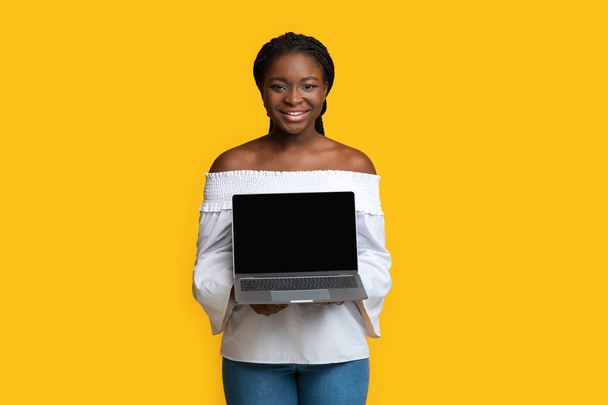 Mocku de laptop com tela preta em mãos de mulher negra sorridente - Foto, Imagem