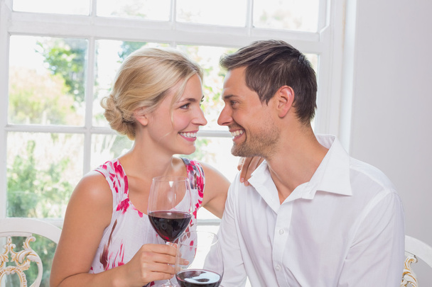 Happy loving couple with wine glasses looking at each other - Foto, afbeelding