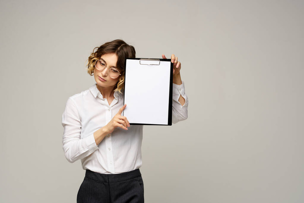 Mujer de negocios con carpeta de documentos en las manos sobre fondo gris vista recortada del trabajo - Foto, Imagen