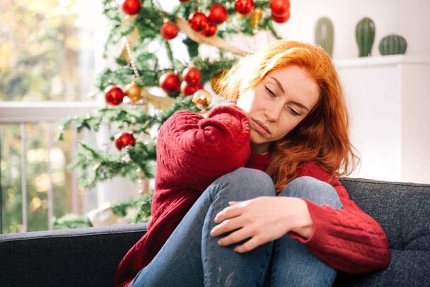 Depressive junge rothaarige Frau im Weihnachtsurlaub - Foto, Bild