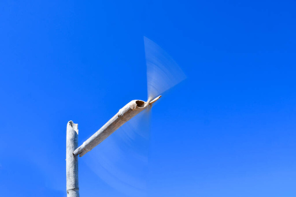 Wind wooden turbine against of blue sky background. Concept of renewable energy - Photo, Image
