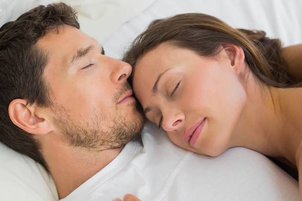 Relaxed couple sleeping together in bed - Foto, afbeelding
