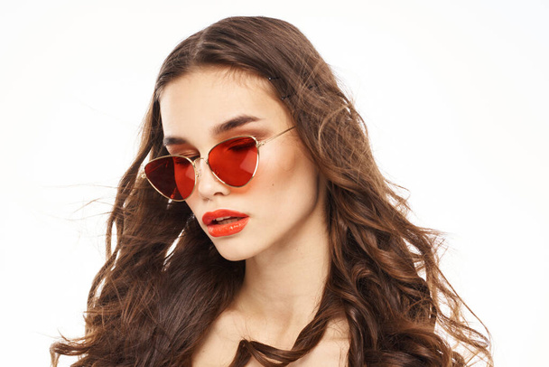 Porträt einer brünetten Frau mit Sonnenbrille nackte Schultern heller Hintergrund - Foto, Bild