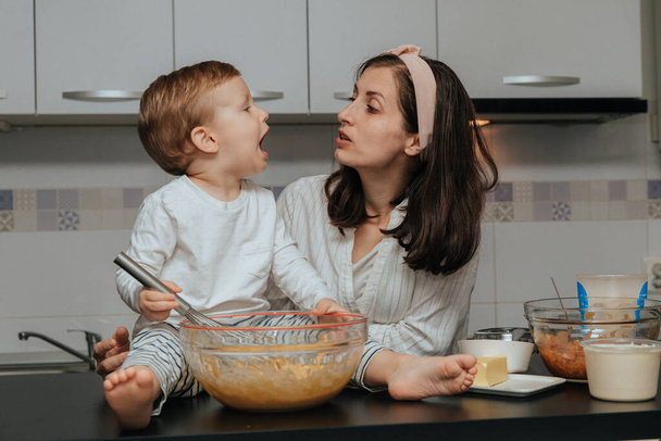 Mother and her boy making apple pie in their home kitchen. - Φωτογραφία, εικόνα