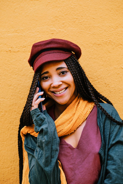 fekete nő copfos telefonhívás okostelefonnal - Fotó, kép