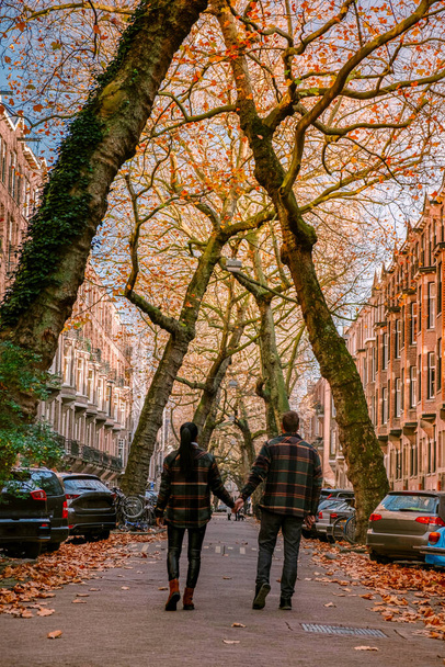 Amsterdam Países Bajos durante la temporada de otoño, pareja de hombres y mujeres visitan la ciudad de Amsterdam con colores naranjas junto al canal en octubre - Foto, Imagen