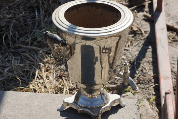 один старий сірий метал відкритий самовар чайник стоїть на вулиці
 - Фото, зображення