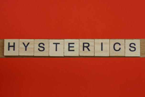 word hysterics from small gray wooden letters lies on a red background - Photo, Image