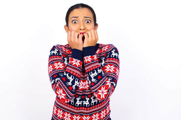 Úzkost. mladá žena nosí svetr zakrývající ústa s rukama vystrašené z něčeho nebo někdo kousání nehty. - Fotografie, Obrázek