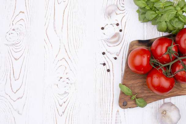 Top view tuoretta basilikaa, valkosipulia ja tomaatteja maalaismainen valkoinen pöytä, tasainen lay, kopioi tilaa. - Valokuva, kuva