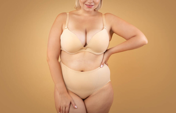 Self Acceptance. Beautiful Curvy Lady In Underwear Posing On Beige Background - Photo, Image