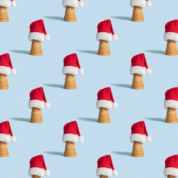 Christmas seamless pattern with ice cream con and Santa hat on light blue background  - Фото, изображение