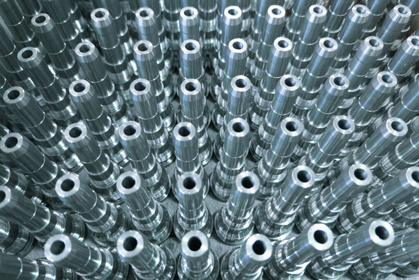 Shiny long steel parts full frame background, clean steel threaded rods after fine cnc turning. Standing vertically in a rows with selective focus and blur. - Photo, Image