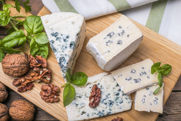 Fourme d'ambert blue cheese  and walnuts. Wooden background. Top view - Photo, Image