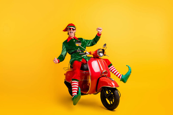 Portrait of his he nice attractive cheerful cheery ecstatic funny guy elf riding moped having fun fooling rejoicing isolated over bright vivid shine vibrant yellow color background - Zdjęcie, obraz