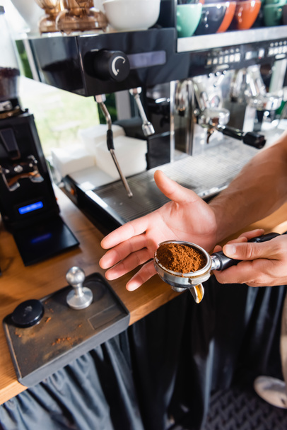 vue partielle de barista tenant portafilter lors de la préparation du café dans le bar - Photo, image