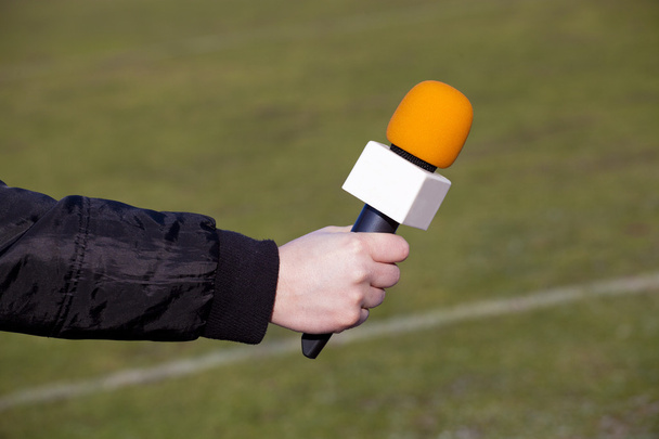 ręka trzymać mikrofon dla wywiad podczas mach piłki nożnej - Zdjęcie, obraz