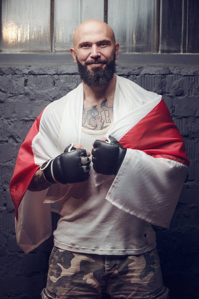 brutal tattooed fighter in fight club with punching bag - Foto, afbeelding