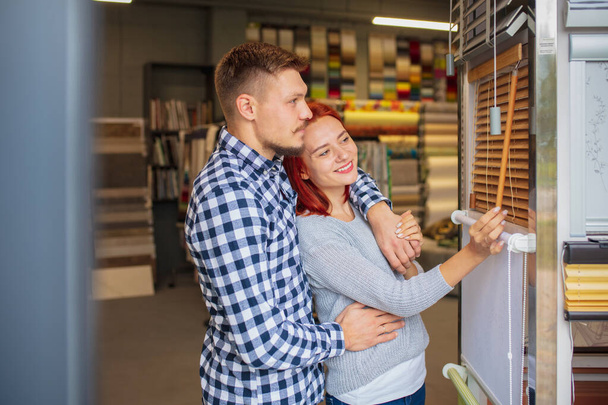 Couple choosing textile at home decoration store, shop. Making of home interior design during quarantine - Фото, зображення