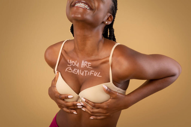 Mulher negra feliz no sutiã com você são bela inscrição no peito - Foto, Imagem