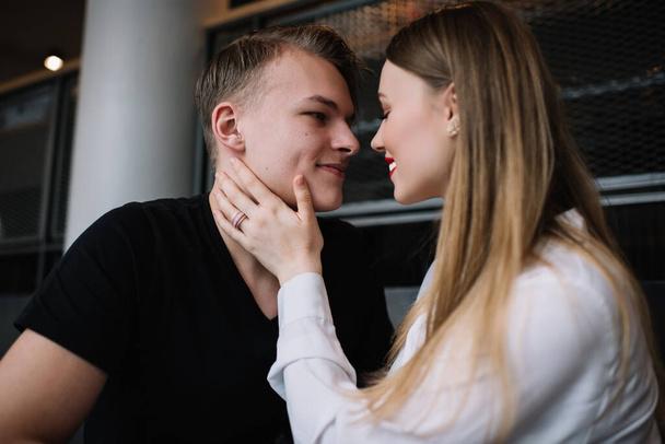 Side view of young man and woman preparing to kiss each other while girlfriend with closed eyes gently touching face of boyfriend - Valokuva, kuva