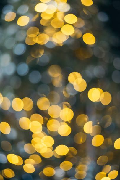 Colorful yellow Christmas Tree Bokeh background of de focused glittering lights. Pattern concept. Festive xmas bokeh defocused lights, close up. - Photo, Image