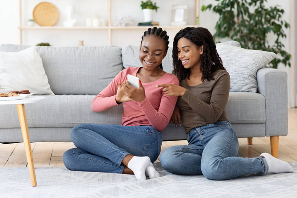 Щасливі чорні жінки використовують новий мобільний додаток
 - Фото, зображення
